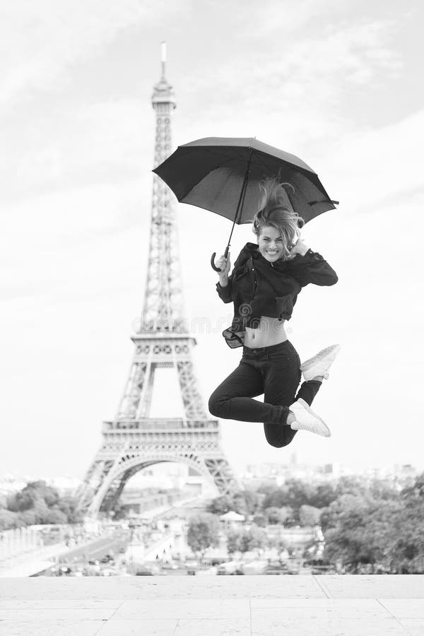 Viaje feliz de la muchacha en París, Francia La mujer salta con el paraguas de la moda Parisiense en el fondo blanco Mujer con imagen de archivo libre de regalías Viaje feliz de la muchacha en París, Francia La mujer salta con el paraguas de la moda Parisiense en el fondo blanco Mujer con imagen de archivo libre de regalías