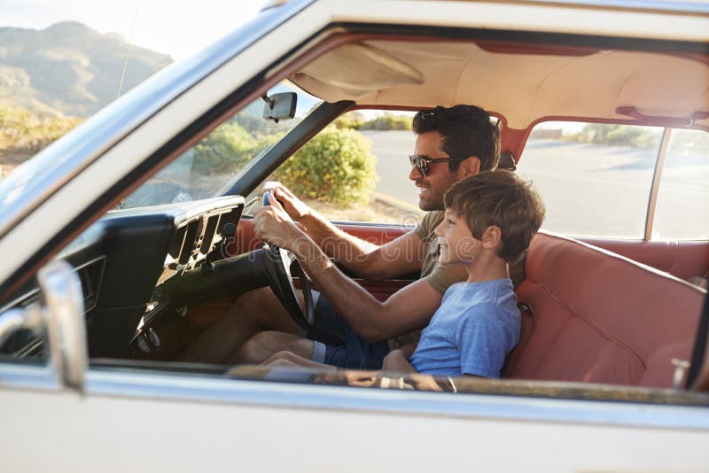 Viaje por carretera de And Son In Front Seat Of Car On del padre imagen de archivo Viaje por carretera de And Son In Front Seat Of Car On del padre imagen de archivo
