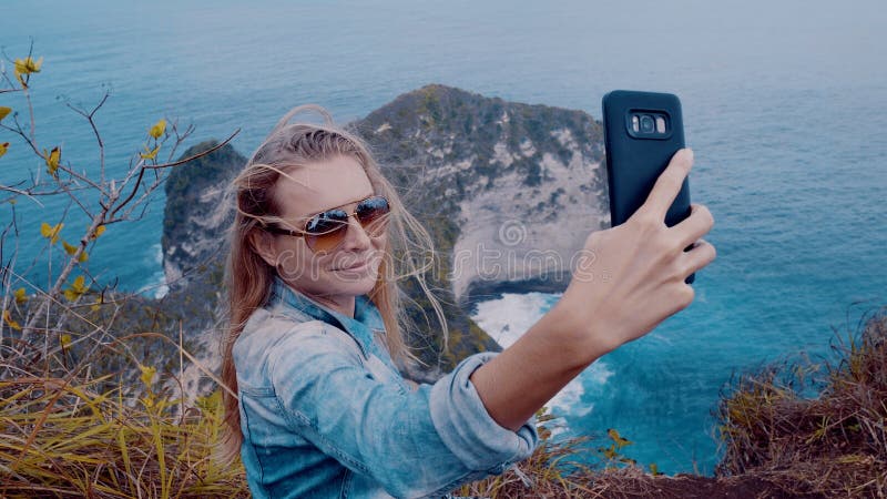 Viajero bonito de la muchacha en la playa de Kelingking en Nusa Penida, Bali foto de archivo libre de regalías Viajero bonito de la muchacha en la playa de Kelingking en Nusa Penida, Bali foto de archivo libre de regalías