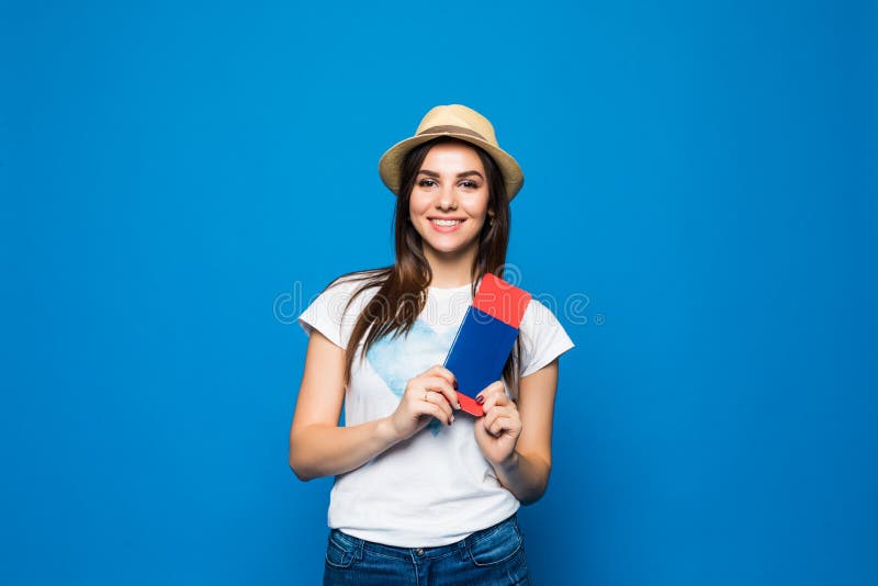 Viajero de la mujer que sostiene el pasaporte con el boleto Retrato de la muchacha feliz sonriente lista para el viaje en fondo a foto de archivo Viajero de la mujer que sostiene el pasaporte con el boleto Retrato de la muchacha feliz sonriente lista para el viaje en fondo a foto de archivo