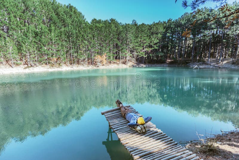Viajero del hombre que camina solamente al lago azul en bosque fotografía de archivo Viajero del hombre que camina solamente al lago azul en bosque fotografía de archivo