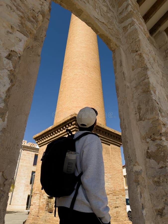 Viajero observando la antigua torre en Mallorca fotografía de archivo