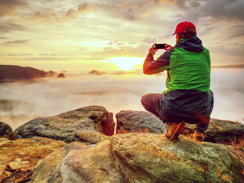 Viajero que toma las fotos móviles de las vacaciones de la puesta del sol hermosa en naturaleza del otoño fotos de archivo libres de regalías Viajero que toma las fotos móviles de las vacaciones de la puesta del sol hermosa en naturaleza del otoño fotos de archivo libres de regalías