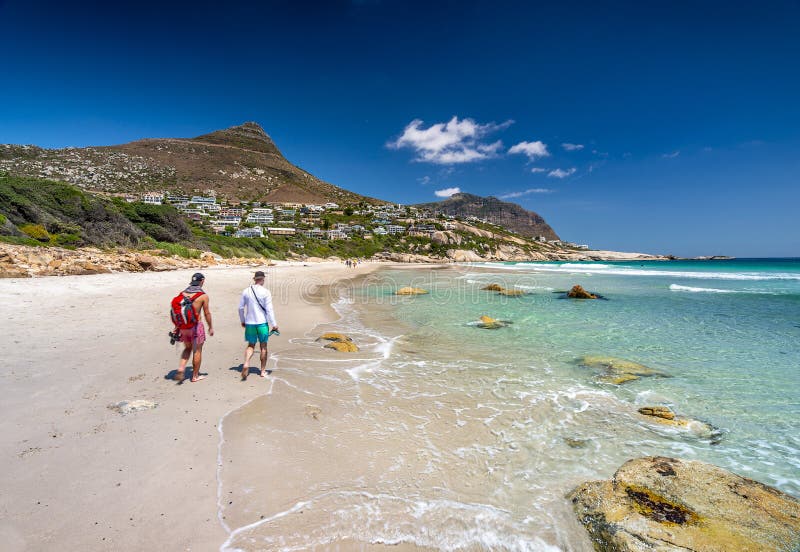 A beautiful secret beach in Cape Town with some beachgoers and turquoise water lapping the white sandn. A beautiful secret beach in Cape Town with some beachgoers and turquoise water lapping the white sandn