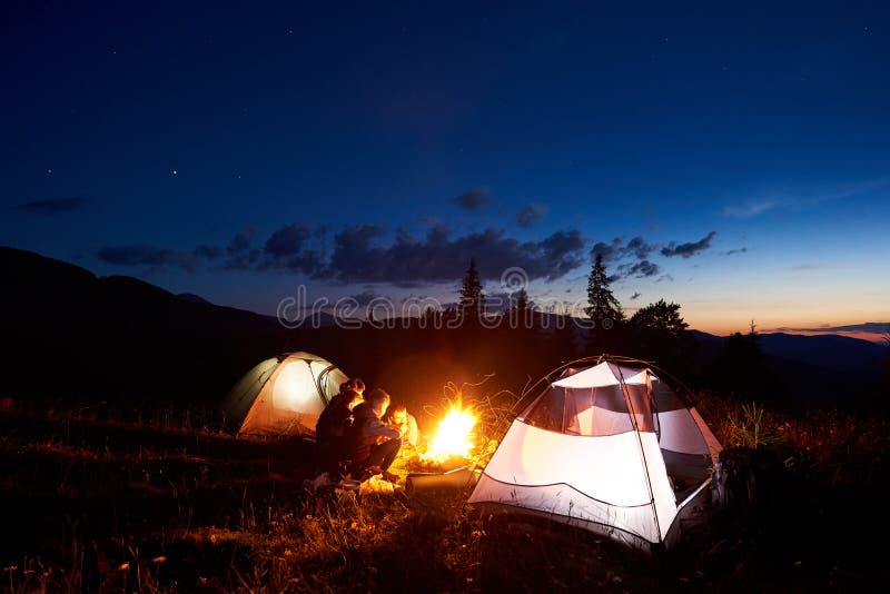 Viandanti della famiglia che hanno un riposo notturno che si accampa in montagne fotografia stock libera da diritti Viandanti della famiglia che hanno un riposo notturno che si accampa in montagne fotografia stock libera da diritti