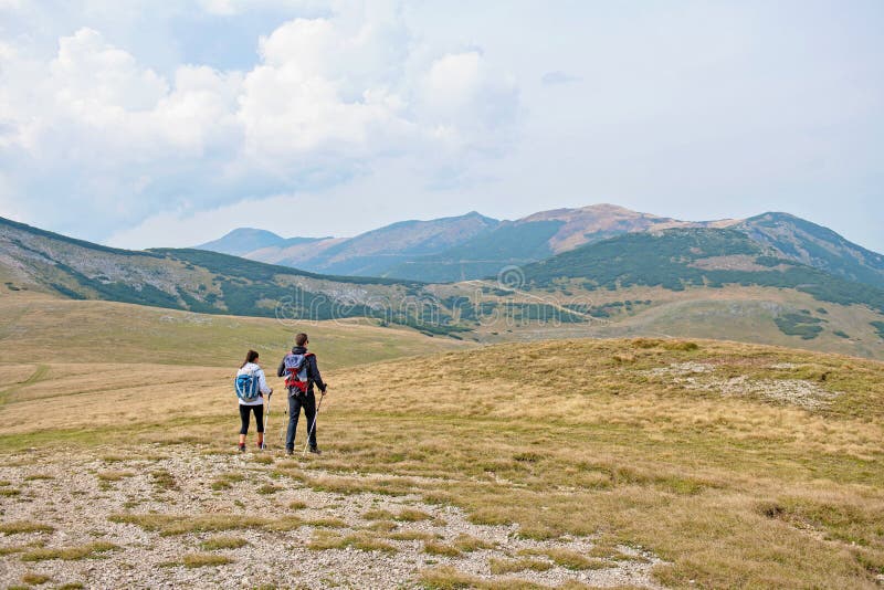 Viandanti sportive sul percorso con i pali di trekking fotografia stock Viandanti sportive sul percorso con i pali di trekking fotografia stock