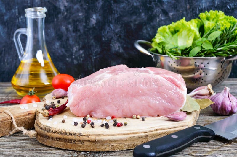 Viande crue Un grand morceau de porc avec les épices et le sel sur une table en bois photographie stock Viande crue Un grand morceau de porc avec les épices et le sel sur une table en bois photographie stock