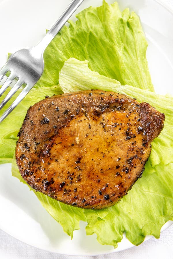 Viande de bifteck avec la feuille de salade de laitue et fourchette dans un plat blanc photographie stock Viande de bifteck avec la feuille de salade de laitue et fourchette dans un plat blanc photographie stock