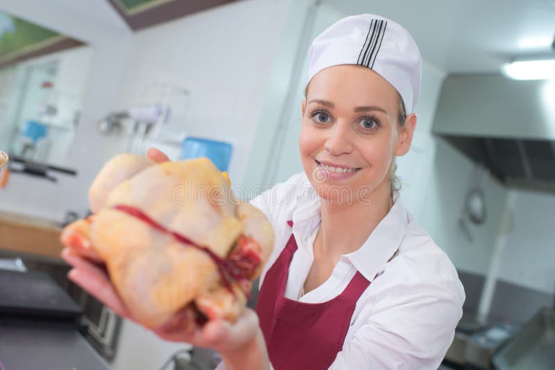 Viande femelle heureuse de coupe de boucher de portrait au compteur de boucherie photo libre de droits Viande femelle heureuse de coupe de boucher de portrait au compteur de boucherie photo libre de droits