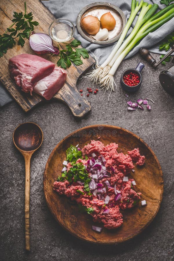 Viande hachée dans le plat avec faire cuire la cuillère avec des ingrédients sur le fond rustique de table de cuisine