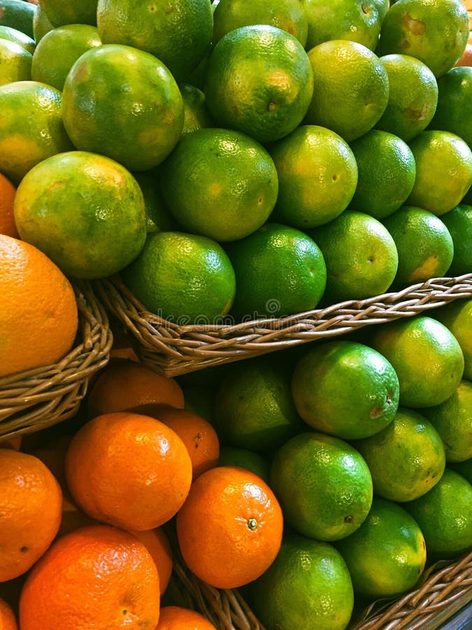 Vibrant display of oranges and limes stock image