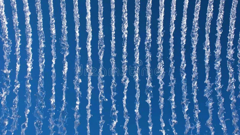 Vibrant display of water streams against a bright blue sky, creating a dynamic, abstract pattern ideal for nature or stock video
