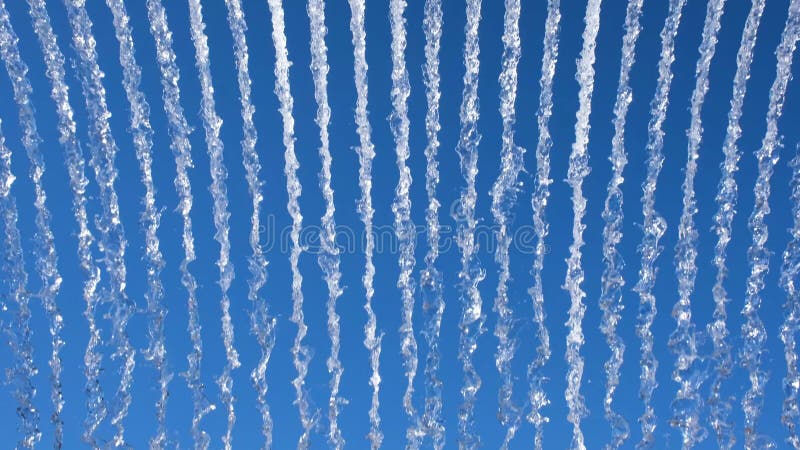 Vibrant display of water streams against a bright blue sky, creating a dynamic, abstract pattern ideal for nature or stock video footage