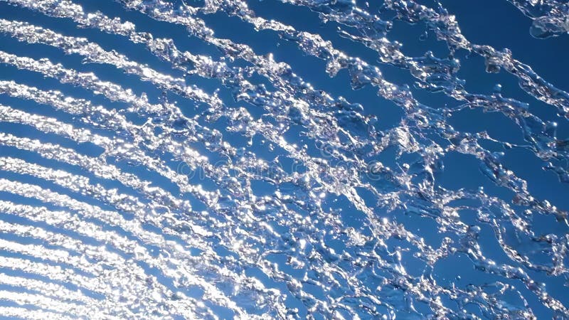 Vibrant display of water streams against a bright blue sky, creating a dynamic, abstract pattern ideal for nature or stock illustration