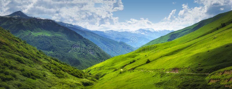 Vibrant mountain landscape. Green meadows on the high hills in Georgia, Svaneti region. Panoramic view on grassy highlands