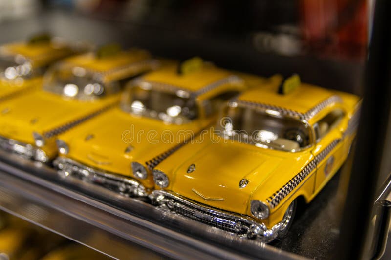 Vibrant yellow model cars with chrome details are neatly aligned on a shelf, classic automotive design stock images