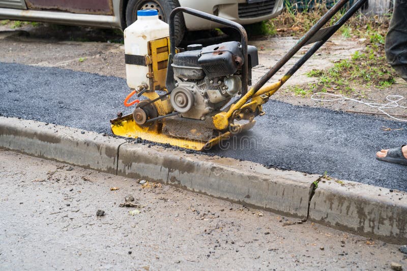 Vibratory plate, a construction tool that performs trambing work of pavement stock photography