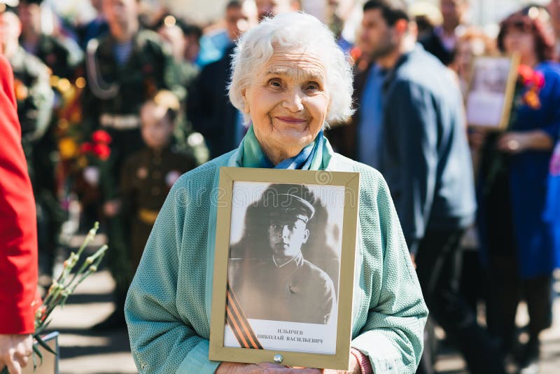 VICHUGA, RUSSIA - MAY 9, 2018: Portrait of a happy smiling old woman at the parade in honor of the victory in world war II. Immortal regiment. VICHUGA, RUSSIA - MAY 9, 2018: Portrait of a happy smiling old woman at the parade in honor of the victory in world war II. Immortal regiment