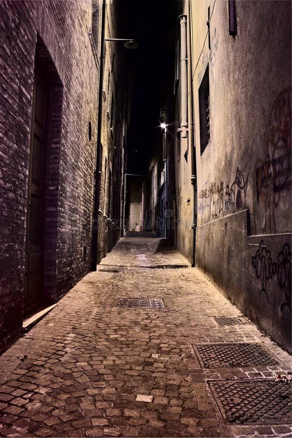 Italian dirty narrow alley at night - dark decadent street in the old town. Italian dirty narrow alley at night - dark decadent street in the old town