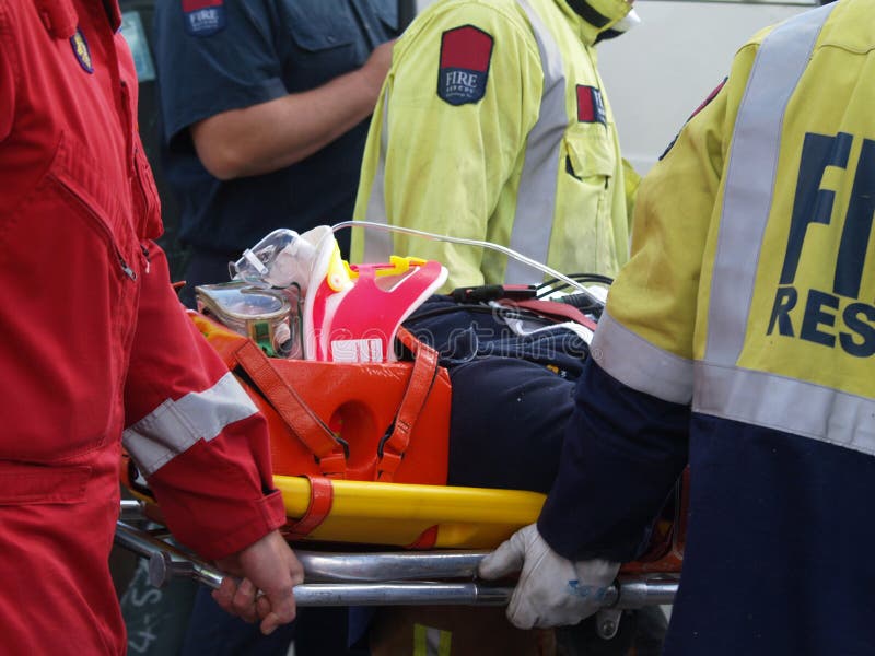 The paramedics & fireman carrying an accident victim to a waiting Helicopter. A simulated training exercise. The paramedics & fireman carrying an accident victim to a waiting Helicopter. A simulated training exercise