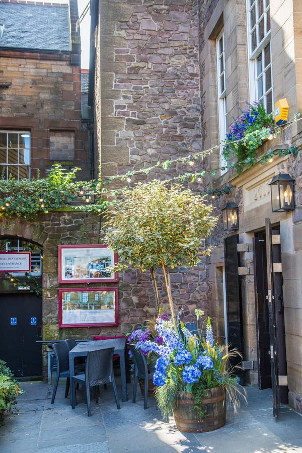 Scotland, Edinburg - August 24, 2022: Victoria street with beautiful curve and colourful shopfronts, built in 1860th and designed in the fashionable Scots Baronial style. Scotland, Edinburg - August 24, 2022: Victoria street with beautiful curve and colourful shopfronts, built in 1860th and designed in the fashionable Scots Baronial style.