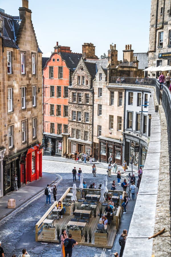 Scotland, Edinburg - August 24, 2022: Victoria street with beautiful curve and colourful shopfronts, built in 1860th and designed in the fashionable Scots Baronial style. Scotland, Edinburg - August 24, 2022: Victoria street with beautiful curve and colourful shopfronts, built in 1860th and designed in the fashionable Scots Baronial style.