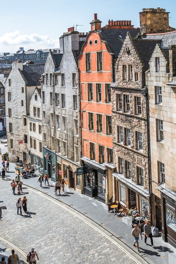 Scotland, Edinburg - August 24, 2022: Victoria street with beautiful curve and colourful shopfronts, built in 1860th and designed in the fashionable Scots Baronial style. Scotland, Edinburg - August 24, 2022: Victoria street with beautiful curve and colourful shopfronts, built in 1860th and designed in the fashionable Scots Baronial style.