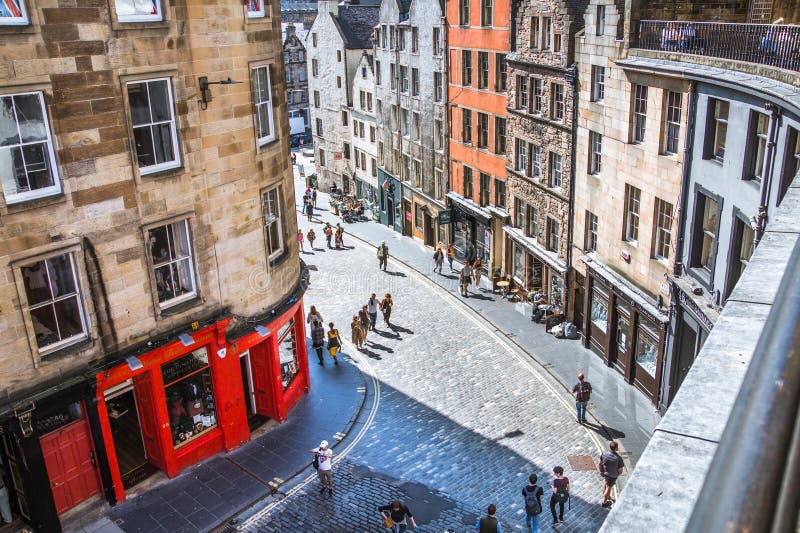 Scotland, Edinburg - August 24, 2022: Victoria street with beautiful curve and colourful shopfronts, built in 1860th and designed in the fashionable Scots Baronial style. Scotland, Edinburg - August 24, 2022: Victoria street with beautiful curve and colourful shopfronts, built in 1860th and designed in the fashionable Scots Baronial style.