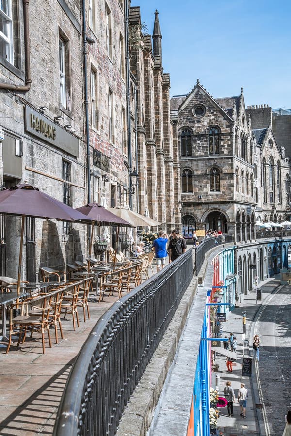 Scotland, Edinburg - August 24, 2022: Victoria street with beautiful curve and colourful shopfronts, built in 1860th and designed in the fashionable Scots Baronial style. Scotland, Edinburg - August 24, 2022: Victoria street with beautiful curve and colourful shopfronts, built in 1860th and designed in the fashionable Scots Baronial style.