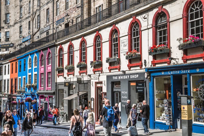 Scotland, Edinburg - August 24, 2022: Victoria street with beautiful curve and colourful shopfronts, built in 1860th and designed in the fashionable Scots Baronial style. Scotland, Edinburg - August 24, 2022: Victoria street with beautiful curve and colourful shopfronts, built in 1860th and designed in the fashionable Scots Baronial style.