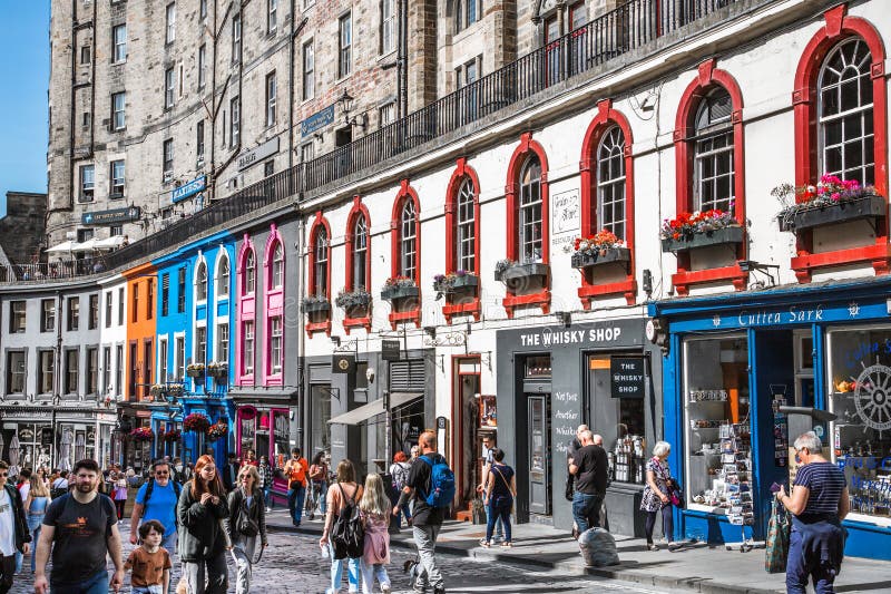 Scotland, Edinburg - August 24, 2022: Victoria street with beautiful curve and colourful shopfronts, built in 1860th and designed in the fashionable Scots Baronial style. Scotland, Edinburg - August 24, 2022: Victoria street with beautiful curve and colourful shopfronts, built in 1860th and designed in the fashionable Scots Baronial style.