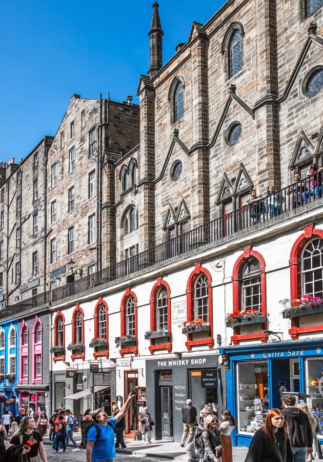 Scotland, Edinburg - August 24, 2022: Victoria street with beautiful curve and colourful shopfronts, built in 1860th and designed in the fashionable Scots Baronial style. Scotland, Edinburg - August 24, 2022: Victoria street with beautiful curve and colourful shopfronts, built in 1860th and designed in the fashionable Scots Baronial style.