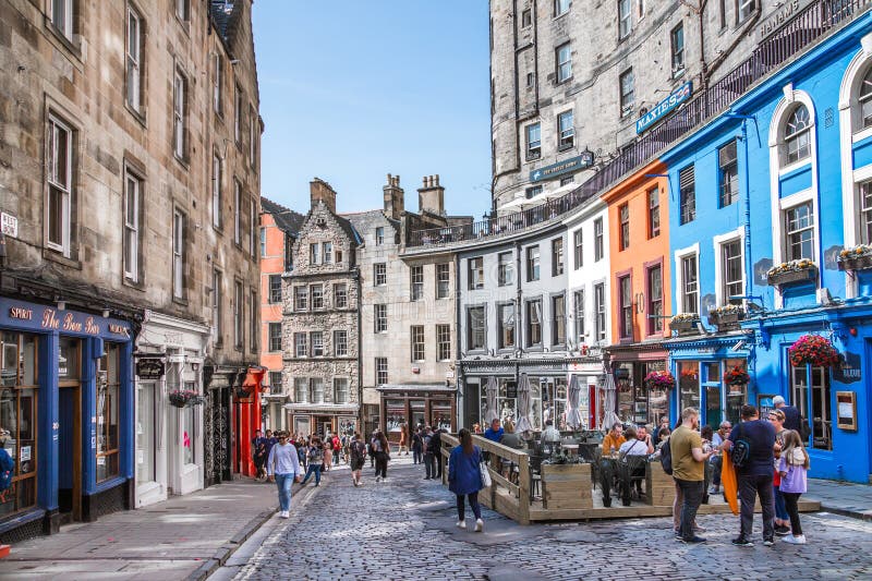 Scotland, Edinburg - August 24, 2022: Victoria street with beautiful curve and colourful shopfronts, built in 1860th and designed in the fashionable Scots Baronial style. Scotland, Edinburg - August 24, 2022: Victoria street with beautiful curve and colourful shopfronts, built in 1860th and designed in the fashionable Scots Baronial style.