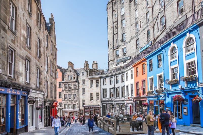 Scotland, Edinburg - August 24, 2022: Victoria street with beautiful curve and colourful shopfronts, built in 1860th and designed in the fashionable Scots Baronial style. Scotland, Edinburg - August 24, 2022: Victoria street with beautiful curve and colourful shopfronts, built in 1860th and designed in the fashionable Scots Baronial style.