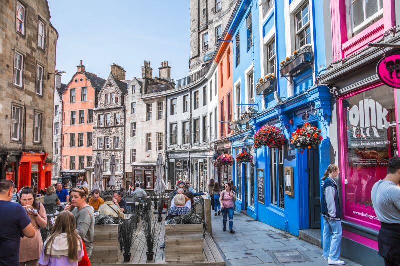 Scotland, Edinburg - August 24, 2022: Victoria street with beautiful curve and colourful shopfronts, built in 1860th and designed in the fashionable Scots Baronial style. Scotland, Edinburg - August 24, 2022: Victoria street with beautiful curve and colourful shopfronts, built in 1860th and designed in the fashionable Scots Baronial style.