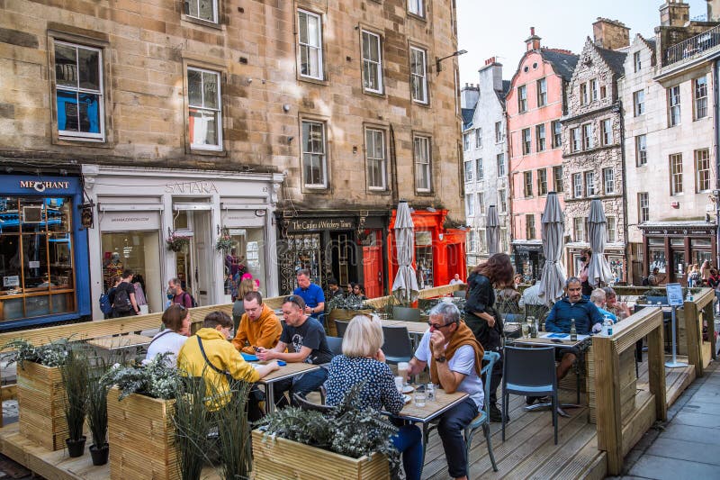 Scotland, Edinburg - August 24, 2022: Victoria street with beautiful curve and colourful shopfronts, built in 1860th and designed in the fashionable Scots Baronial style. Scotland, Edinburg - August 24, 2022: Victoria street with beautiful curve and colourful shopfronts, built in 1860th and designed in the fashionable Scots Baronial style.