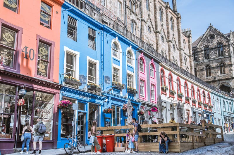 Scotland, Edinburg - August 24, 2022: Victoria street with beautiful curve and colourful shopfronts, built in 1860th and designed in the fashionable Scots Baronial style. Scotland, Edinburg - August 24, 2022: Victoria street with beautiful curve and colourful shopfronts, built in 1860th and designed in the fashionable Scots Baronial style.