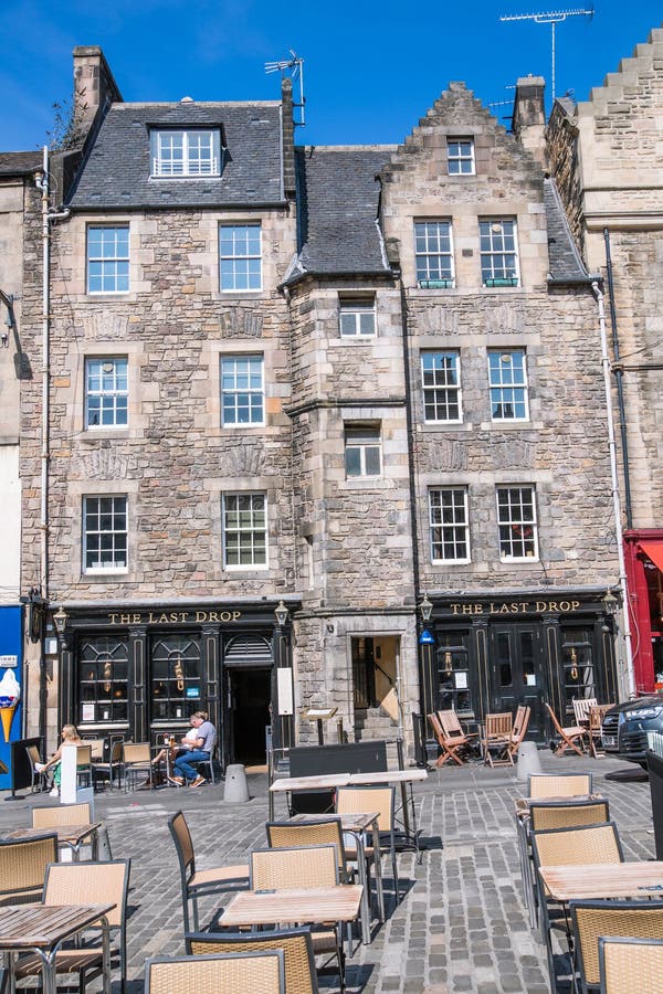 Scotland, Edinburg - August 24, 2022: Victoria street with beautiful curve and colourful shopfronts, built in 1860th and designed in the fashionable Scots Baronial style. Scotland, Edinburg - August 24, 2022: Victoria street with beautiful curve and colourful shopfronts, built in 1860th and designed in the fashionable Scots Baronial style.