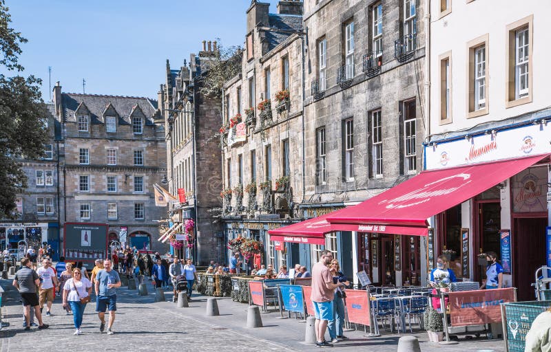 Scotland, Edinburg - August 24, 2022: Victoria street with beautiful curve and colourful shopfronts, built in 1860th and designed in the fashionable Scots Baronial style. Scotland, Edinburg - August 24, 2022: Victoria street with beautiful curve and colourful shopfronts, built in 1860th and designed in the fashionable Scots Baronial style.