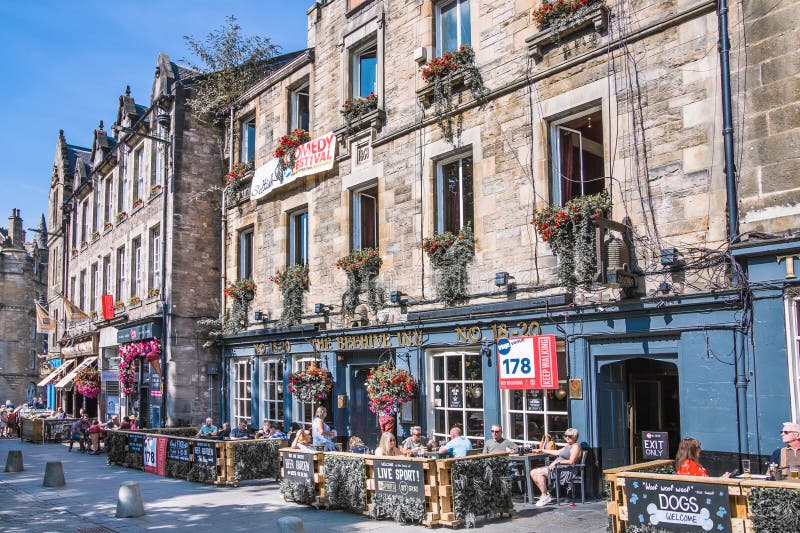 Scotland, Edinburg - August 24, 2022: Victoria street with beautiful curve and colourful shopfronts, built in 1860th and designed in the fashionable Scots Baronial style. Scotland, Edinburg - August 24, 2022: Victoria street with beautiful curve and colourful shopfronts, built in 1860th and designed in the fashionable Scots Baronial style.