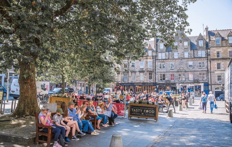 Scotland, Edinburg - August 24, 2022: Victoria street with beautiful curve and colourful shopfronts, built in 1860th and designed in the fashionable Scots Baronial style. Scotland, Edinburg - August 24, 2022: Victoria street with beautiful curve and colourful shopfronts, built in 1860th and designed in the fashionable Scots Baronial style.