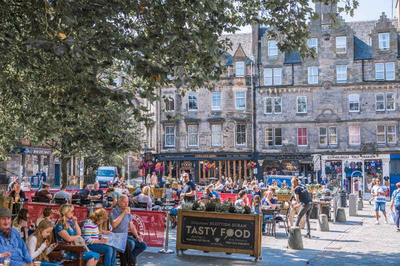 Scotland, Edinburg - August 24, 2022: Victoria street with beautiful curve and colourful shopfronts, built in 1860th and designed in the fashionable Scots Baronial style. Scotland, Edinburg - August 24, 2022: Victoria street with beautiful curve and colourful shopfronts, built in 1860th and designed in the fashionable Scots Baronial style.