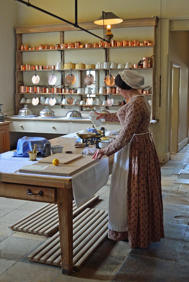 Victorian Kitchen maid - Cook preparing food . in authentic Victorian kitchen.