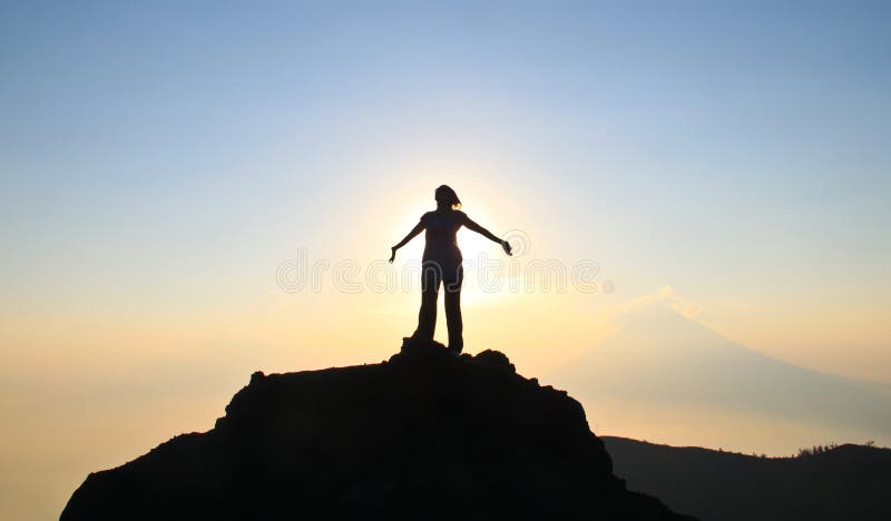 A woman's silhouette celebrating victory on top of volcano Pacaya during sunset, Guatemala. A woman's silhouette celebrating victory on top of volcano Pacaya during sunset, Guatemala