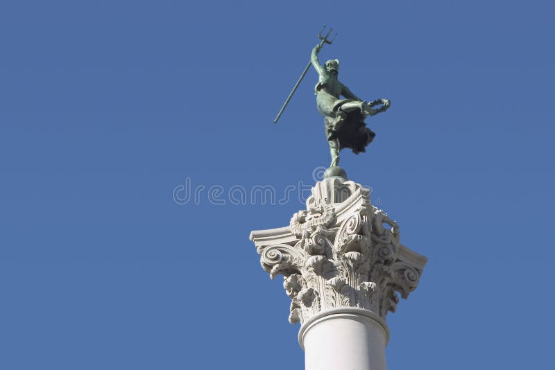 A female victory statue, atop a column, raises a trident into the air. A female victory statue, atop a column, raises a trident into the air.