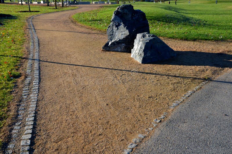 Vid ingången till cykelbanan eller parken placeras en stor sten mitt på vägen som en barriär mot bilen. nästa fotografering för bildbyråer