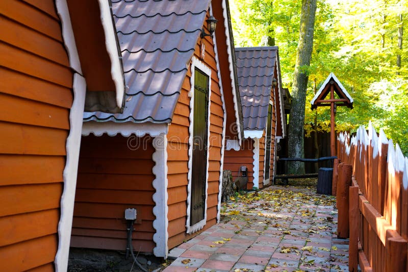This video captures a serene relaxation area in a forested setting. Rustic hut structures are nestled among lush green stock photos