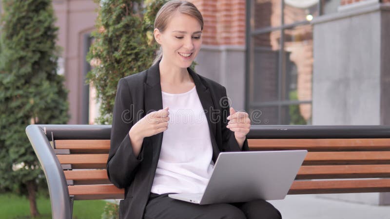 Video chiacchierata online sul computer portatile dalla giovane donna di affari Sitting sul banco