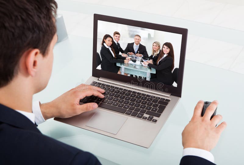 Video comunicazione dell'uomo d'affari sul computer portatile in ufficio immagini stock