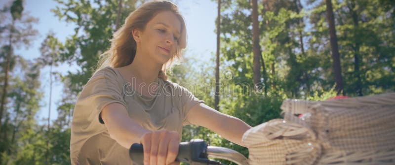 Video de cierre de una mujer montando una bicicleta en un día soleado. almacen de metraje de vídeo